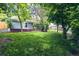Green backyard with lush lawn, mature trees and brick patio foundation at 4854 S Parfet St, Littleton, CO 80127