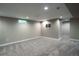 Basement area featuring neutral carpet, a small window, a TV mount, and access to adjacent rooms at 4854 S Parfet St, Littleton, CO 80127
