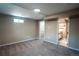 Spacious basement area features neutral carpet, a window, and access to an adjacent updated bathroom at 4854 S Parfet St, Littleton, CO 80127
