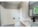 Bathroom featuring a shower-tub combination with white tile surround and a modern vanity with sleek fixtures at 4854 S Parfet St, Littleton, CO 80127