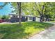 Inviting home exterior with a lush front lawn and mature trees providing ample shade and curb appeal at 4854 S Parfet St, Littleton, CO 80127