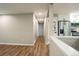 Bright hallway with hardwood floors, leading to a modern kitchen with stainless steel appliances and white cabinets at 4854 S Parfet St, Littleton, CO 80127