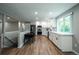 Well-lit kitchen with white cabinets, modern appliances, and an adjacent dining area at 4854 S Parfet St, Littleton, CO 80127