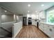 Open-concept kitchen boasts white cabinets, stainless steel appliances, and abundant natural light at 4854 S Parfet St, Littleton, CO 80127