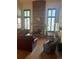 Spacious living room with a brick fireplace, hardwood floors, and bright windows with wood shutters at 14131 E Baltic Pl, Aurora, CO 80014