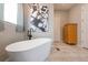 Elegant bathroom featuring standalone tub, modern fixtures, and large decorative art at 14232 Elm St, Thornton, CO 80602