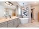Bathroom featuring soaking tub, pendant lighting, and access to walk-in closet at 14232 Elm St, Thornton, CO 80602