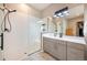 Modern bathroom featuring walk-in shower with glass door and gray vanity at 14232 Elm St, Thornton, CO 80602