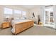 Bright bedroom with natural wood furniture, neutral decor, and sliding glass door at 14232 Elm St, Thornton, CO 80602