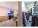 View of a well-organized walk-in closet and primary bedroom featuring a barn door and a fish tank at 14232 Elm St, Thornton, CO 80602
