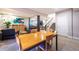Open basement dining area with a long wooden table, grey chairs, nearby living area, and view of the staircase at 14232 Elm St, Thornton, CO 80602