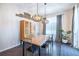 Dining room with modern light fixture, wood table and chairs, and decorative wall decor at 14232 Elm St, Thornton, CO 80602