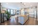 Open-concept kitchen and living area featuring modern appliances, an island with seating, and a cozy fireplace at 14232 Elm St, Thornton, CO 80602