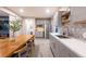 Charming kitchen area with grey tiling, stainless steel appliances, wood shelves, and a breakfast nook at 14232 Elm St, Thornton, CO 80602