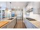 Bright, open kitchen with stainless steel appliances, granite countertops, and dark hardwood flooring at 14232 Elm St, Thornton, CO 80602