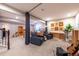 Spacious living room area with two dark blue couches, a view of the stairs, and a view of the play area at 14232 Elm St, Thornton, CO 80602