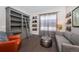 Inviting sitting room with a built-in bookcase and a cozy couch, illuminated by a natural light at 14232 Elm St, Thornton, CO 80602