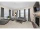 Bright living room features gray decor, large windows, and a fireplace with built-in shelving at 14232 Elm St, Thornton, CO 80602