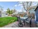 Backyard with a brick patio, dining set, mature tree, and lawn, perfect for outdoor relaxation and entertaining at 2244 N Washington St, Denver, CO 80205