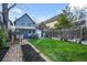 Backyard with dining set, grill, playhouse, grass, and garden beds, providing a versatile outdoor space at 2244 N Washington St, Denver, CO 80205