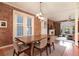 Inviting dining room with exposed brick walls, wood table, and modern chandelier, flowing into a cozy living area at 2244 N Washington St, Denver, CO 80205
