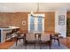 Elegant dining area featuring a rustic wood table, brick wall, and modern chandelier at 2244 N Washington St, Denver, CO 80205