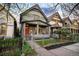 Charming two-story home boasts a welcoming front porch, gray brick facade, and well-manicured lawn at 2244 N Washington St, Denver, CO 80205