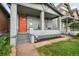 Inviting front porch with a red door, gray brick, and a cozy seating area at 2244 N Washington St, Denver, CO 80205
