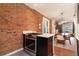 Modern kitchen with stainless steel oven, exposed brick accent wall, and an open layout to the dining room at 2244 N Washington St, Denver, CO 80205