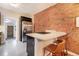 Stylish kitchen featuring exposed brick, a breakfast bar with seating, and modern stainless steel appliances at 2244 N Washington St, Denver, CO 80205
