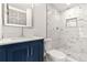 Stylish bathroom showcasing a blue vanity, elegant white marble tile in the walk-in shower, and modern fixtures at 2441 Niagara St, Denver, CO 80207