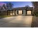 Charming painted brick home featuring a large driveway, covered porch, and manicured landscaping at 2441 Niagara St, Denver, CO 80207