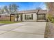 Charming painted brick home featuring a large driveway, covered porch, and manicured landscaping at 2441 Niagara St, Denver, CO 80207