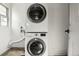 Efficient laundry room with a stacked washer and dryer and a small window at 2441 Niagara St, Denver, CO 80207