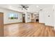 Open-concept living room with wood floors, large window, and view into updated kitchen at 2441 Niagara St, Denver, CO 80207
