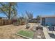 Backyard with patio area, blue chairs, fire pit, greenhouse, and bench seating, great for entertaining at 7940 Pontiac St, Commerce City, CO 80022