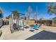 Backyard area with blue chairs, outdoor seating, fire pit, and hanging swing set under clear blue sky at 7940 Pontiac St, Commerce City, CO 80022
