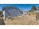 Backyard with patio area, blue chairs, firepit, storage shed and small tree stump at 7940 Pontiac St, Commerce City, CO 80022