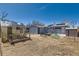 Backyard with patio area, blue chairs, firepit, greenhouse, storage shed and small patch of green grass at 7940 Pontiac St, Commerce City, CO 80022