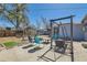Backyard area with blue chairs, outdoor seating, fire pit, and hanging swing under clear blue sky at 7940 Pontiac St, Commerce City, CO 80022