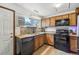 Functional kitchen featuring wood cabinets, a granite countertop, and modern appliances at 7940 Pontiac St, Commerce City, CO 80022