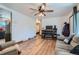 Light-filled living room boasts wood floors, a ceiling fan, and a cozy fireplace with an open design at 7940 Pontiac St, Commerce City, CO 80022