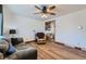 The living room has wood floors, a ceiling fan, and a doorway leading to shelving and other rooms at 7940 Pontiac St, Commerce City, CO 80022