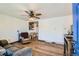The living room features hard wood floors, a ceiling fan, and an open doorway to shelving and the kitchen at 7940 Pontiac St, Commerce City, CO 80022