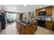 Bright open kitchen with a central island featuring a cooktop and bar seating, adjacent to living spaces at 6376 S Estes St, Littleton, CO 80123