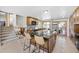 Open kitchen featuring a large island with seating, leading to a staircase and cozy dining area with sliding doors at 6376 S Estes St, Littleton, CO 80123