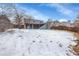 Snowy backyard view of the deck, patio and tiered yard at 4678 S Salida St, Aurora, CO 80015