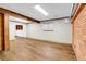 Unfinished basement featuring wood flooring, exposed beams and a brick accent wall at 4678 S Salida St, Aurora, CO 80015