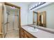 Bright bathroom with a vanity, sink, large mirror, updated lighting and a shower with glass doors at 2585 E Egbert St, Brighton, CO 80601