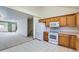 This kitchen transitions to the carpeted living room, featuring white appliances, and ample cabinet space at 2585 E Egbert St, Brighton, CO 80601